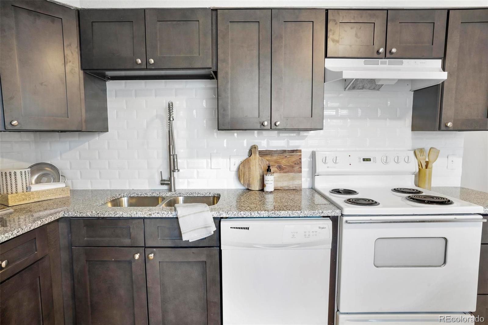 5522 Carson Street Denver, CO 80239 - Photo 13 of 40 a kitchen with stainless steel appliances granite countertop a sink stove and cabinets
