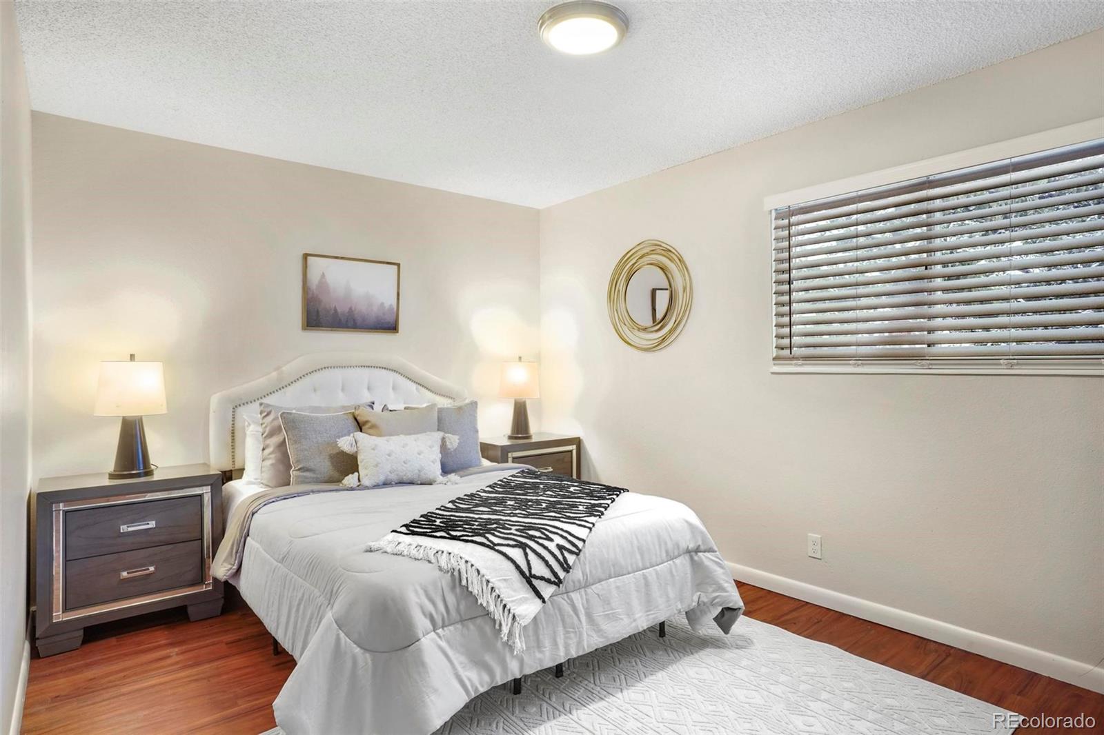 5522 Carson Street Denver, CO 80239 - Photo 18 of 40 a bedroom with a bed and a night stand