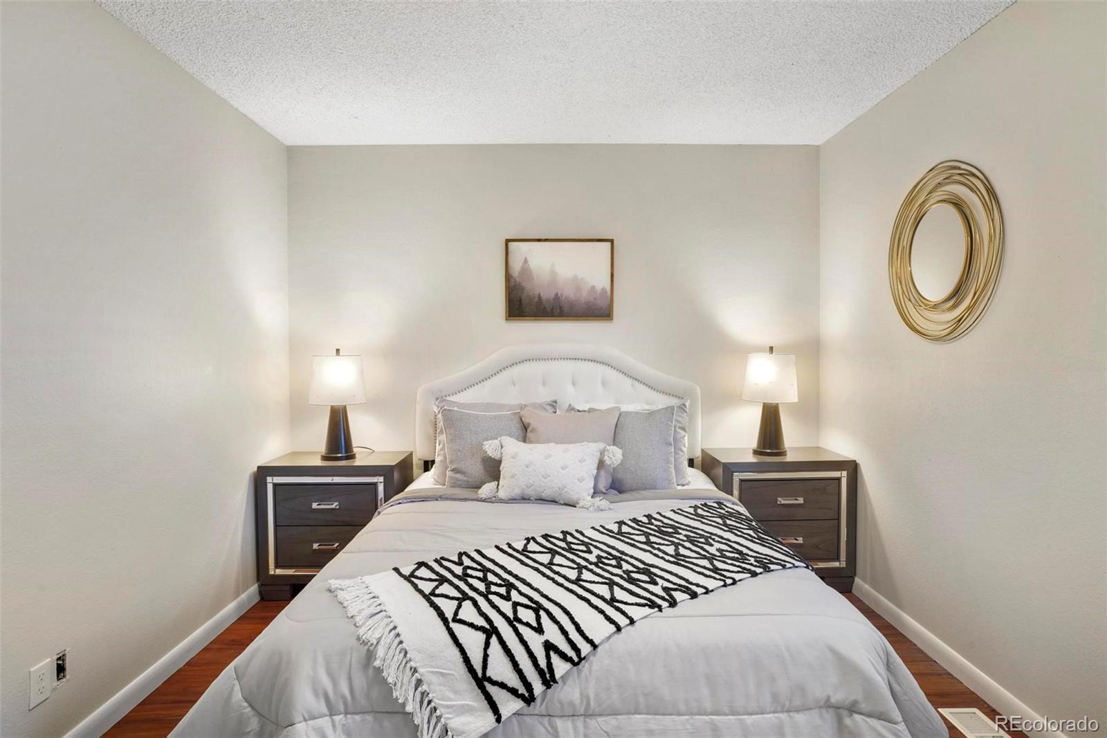 5522 Carson Street Denver, CO 80239 - Photo 19 of 40 a bedroom with a bed and a lamp on dresser