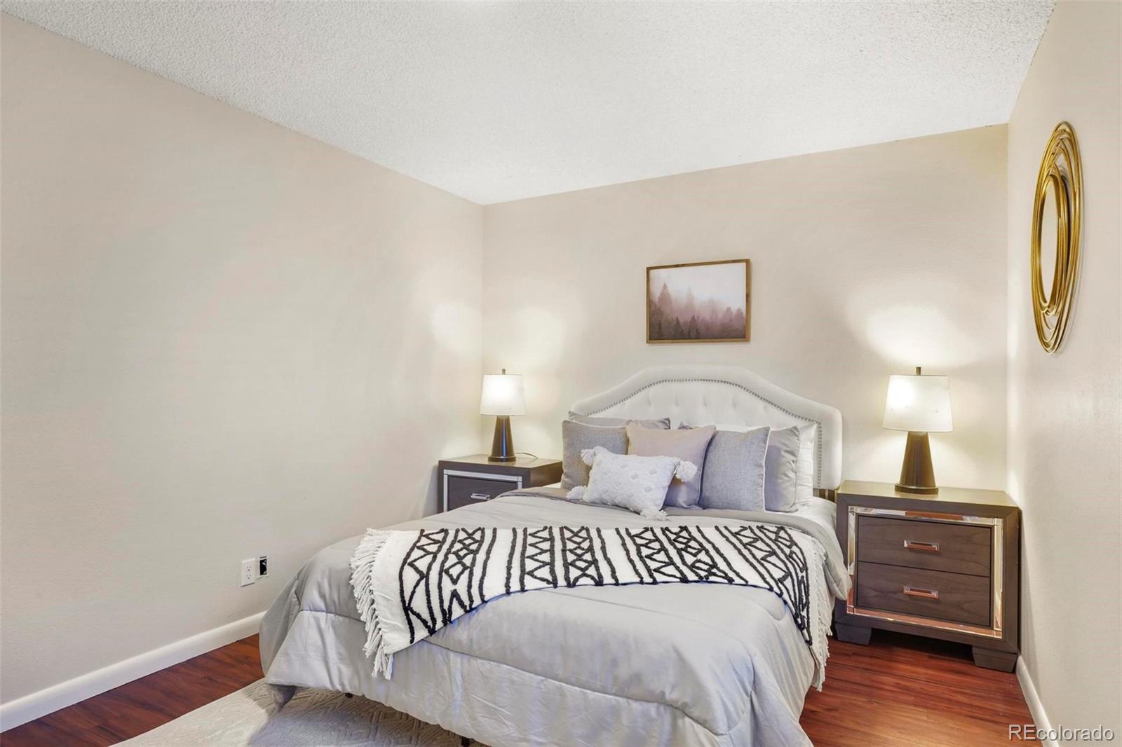 5522 Carson Street Denver, CO 80239 - Photo 20 of 40 a bedroom with a bed and wooden floor