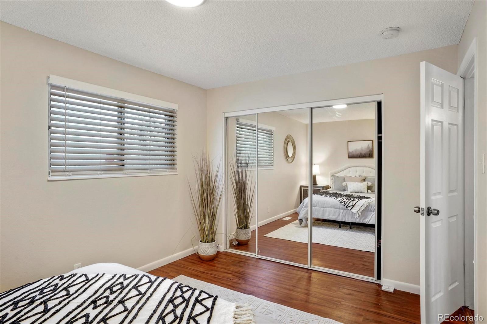 5522 Carson Street Denver, CO 80239 - Photo 21 of 40 a bedroom with a bed and a mirror