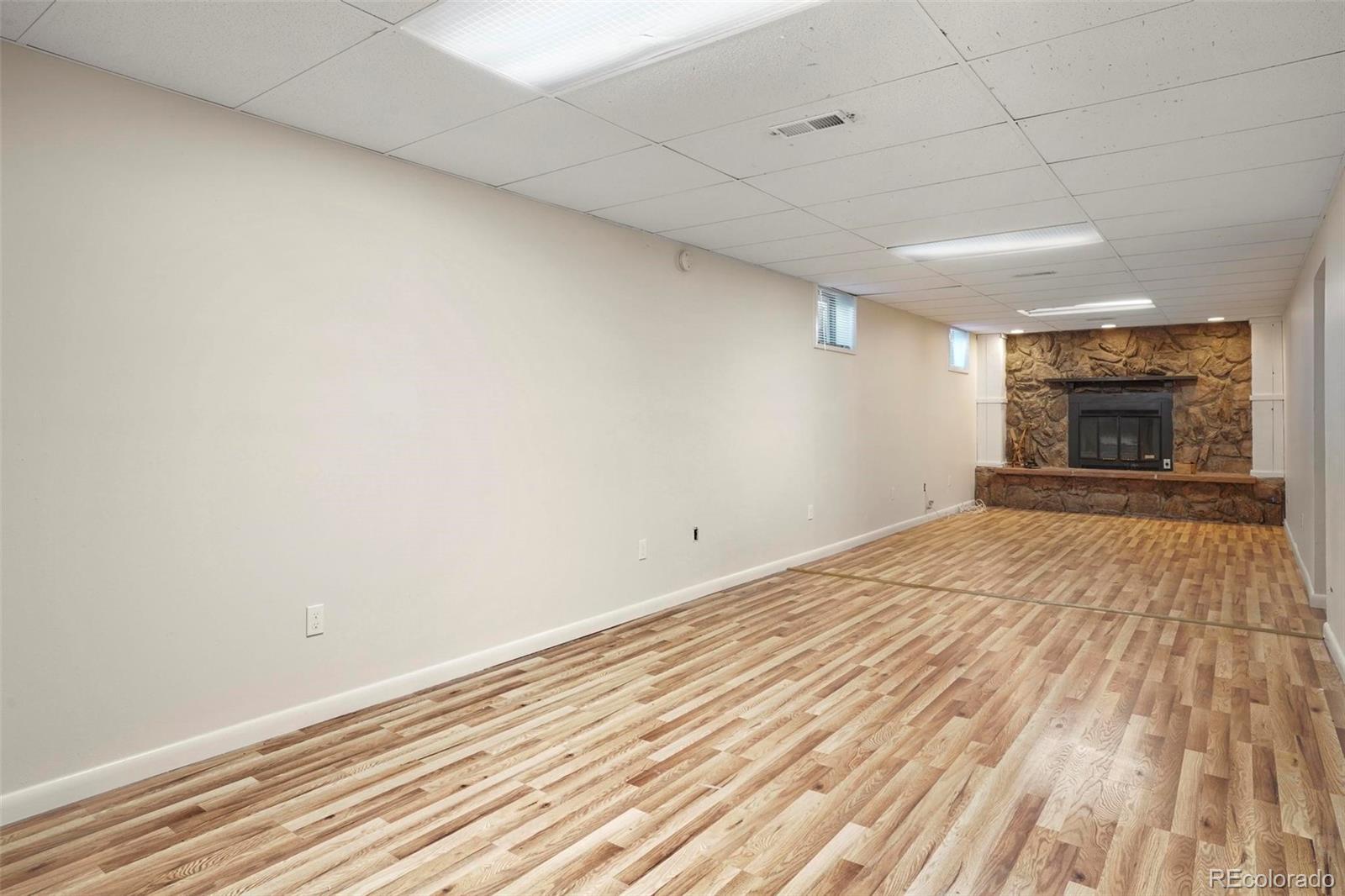 5522 Carson Street Denver, CO 80239 - Photo 25 of 40 a view of empty room with wooden floor and fan