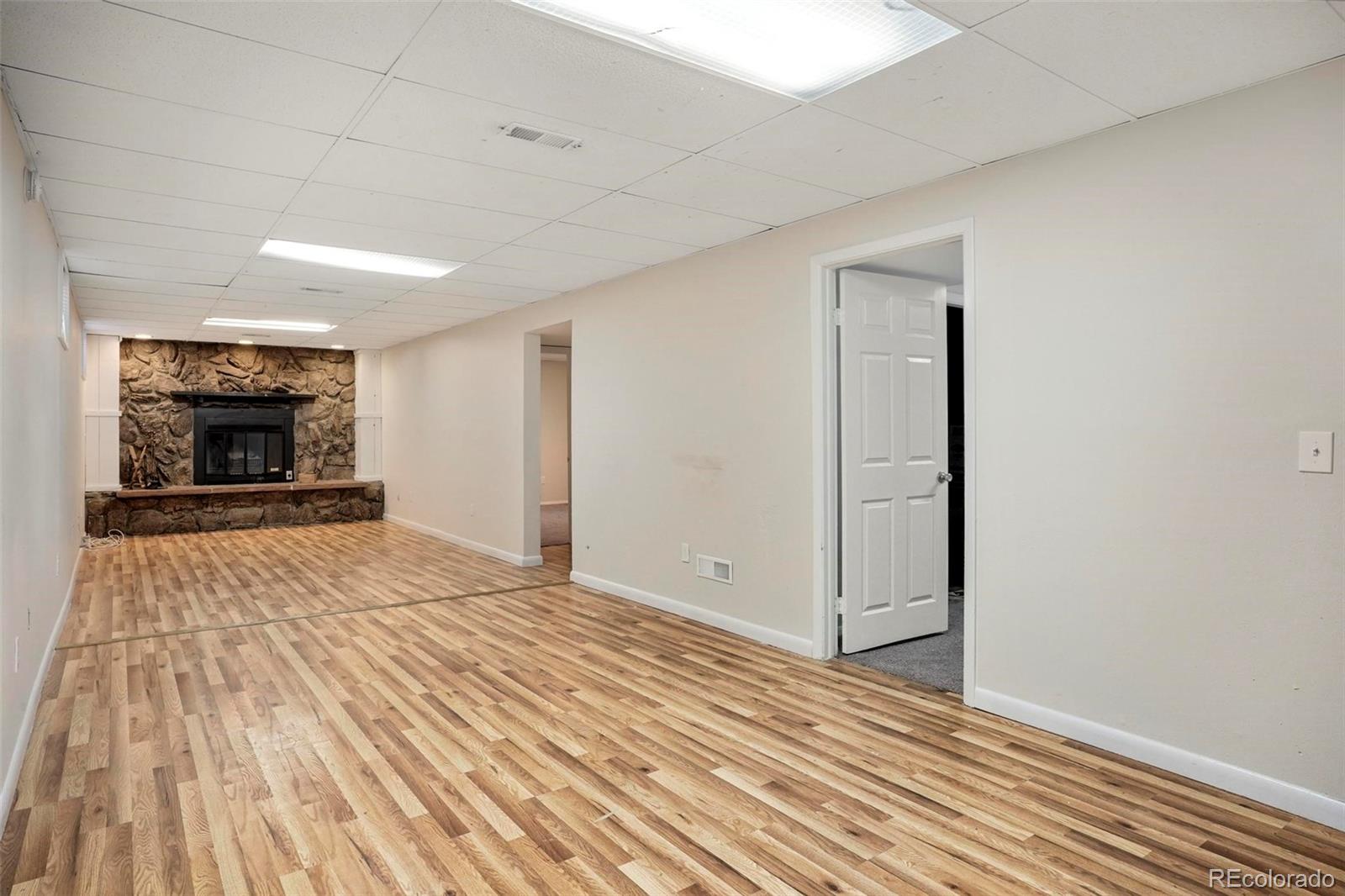 5522 Carson Street Denver, CO 80239 - Photo 26 of 40 a view of empty room with wooden floor and fireplace