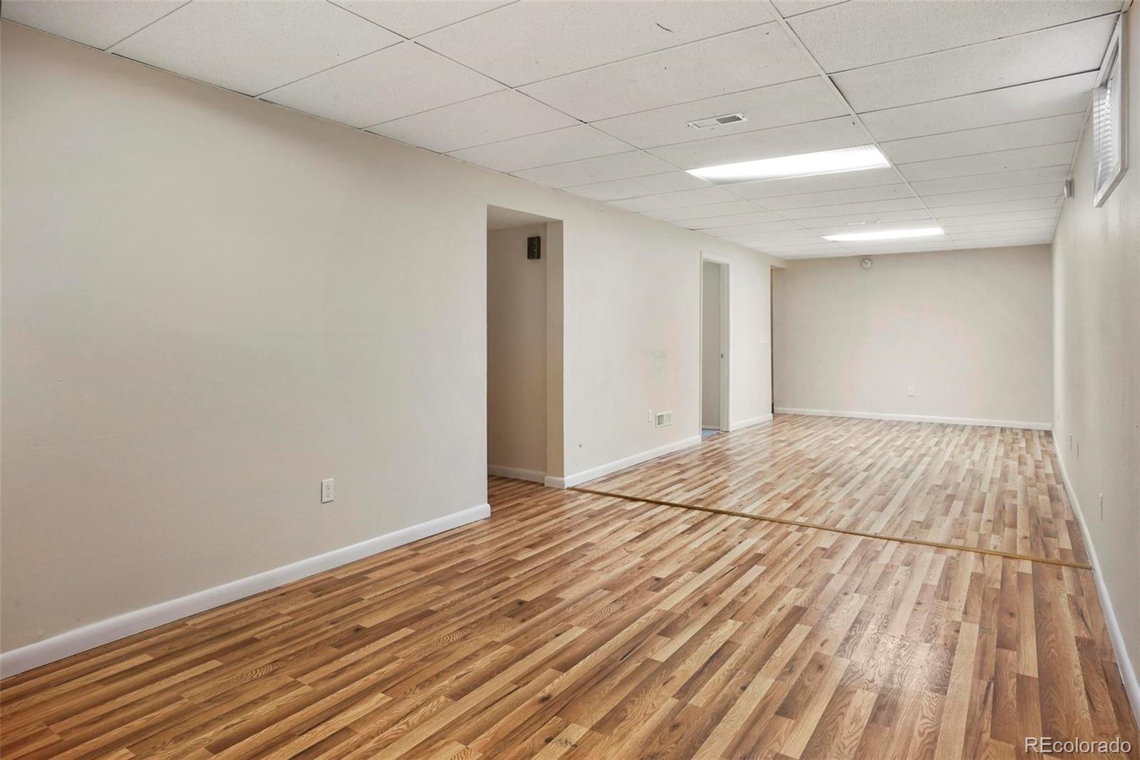 5522 Carson Street Denver, CO 80239 - Photo 27 of 40 a view of empty room with wooden floor