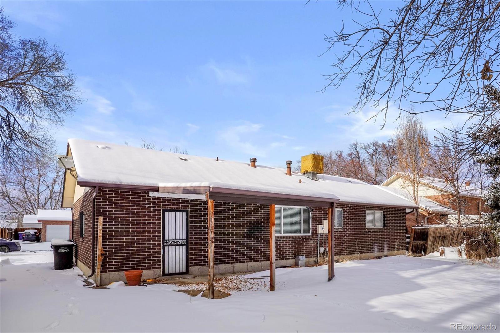5522 Carson Street Denver, CO 80239 - Photo 33 of 40 a view of a patio with a table and chairs under an umbrella