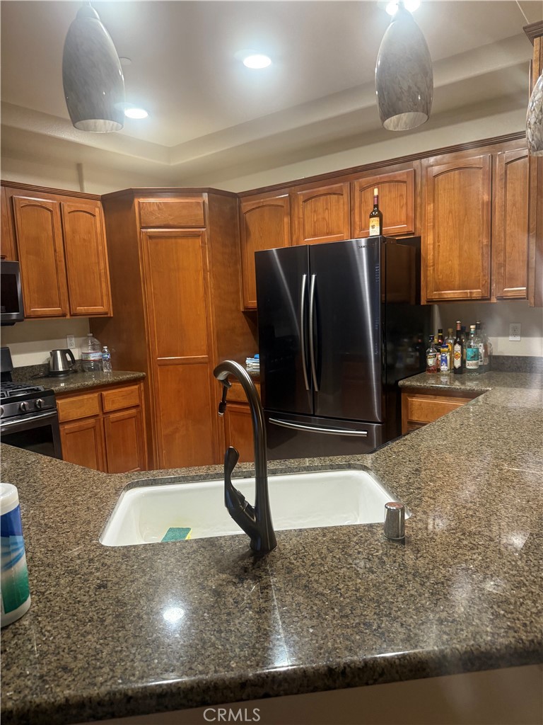 4778 Luna Road Phelan, CA 92371 - Photo 6 of 6 a kitchen with stainless steel appliances granite countertop a sink a stove and a refrigerator
