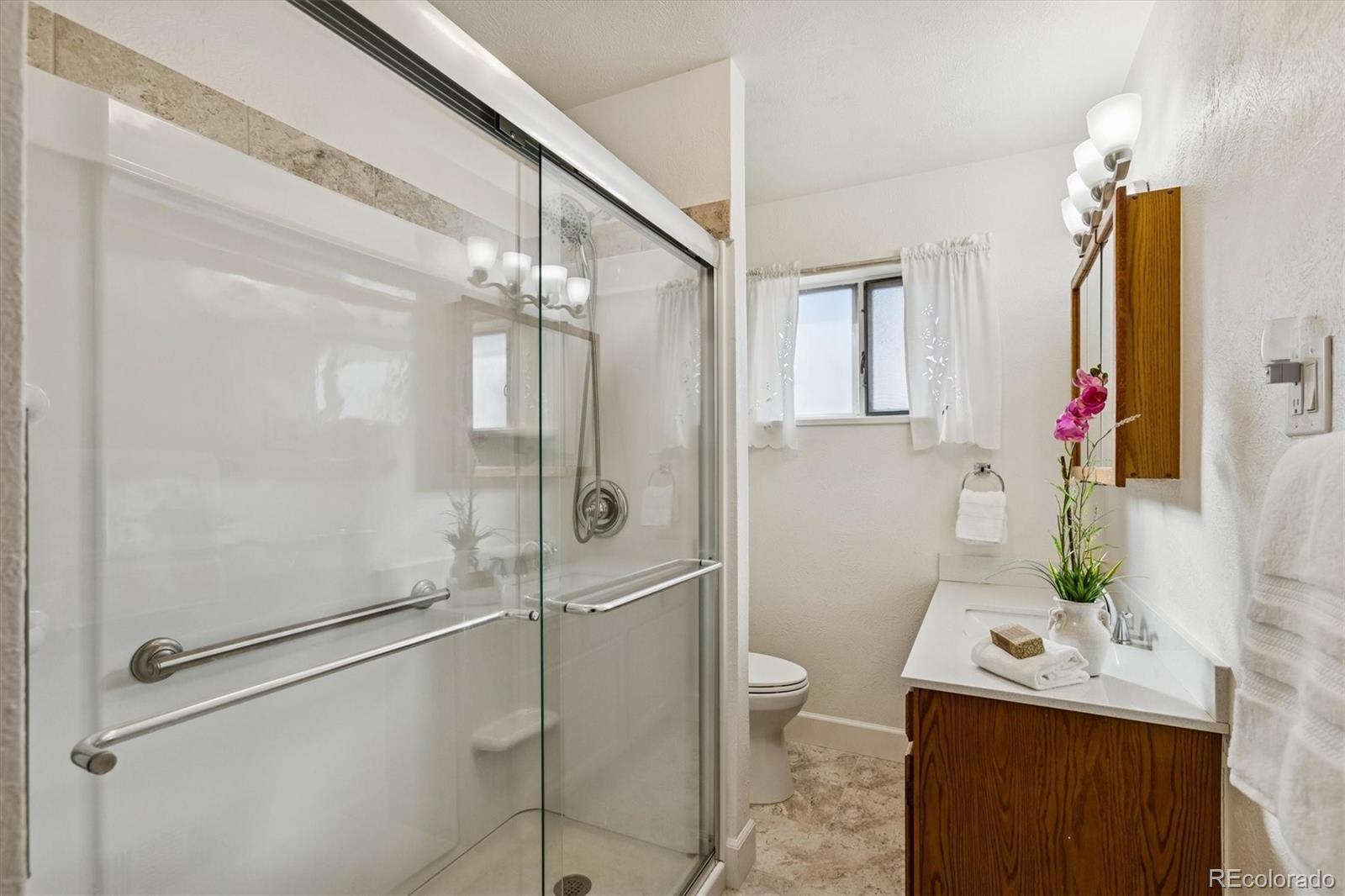 7798 Quivas Street Denver, CO 80221 - Photo 15 of 39 a bathroom with a sink toilet and shower