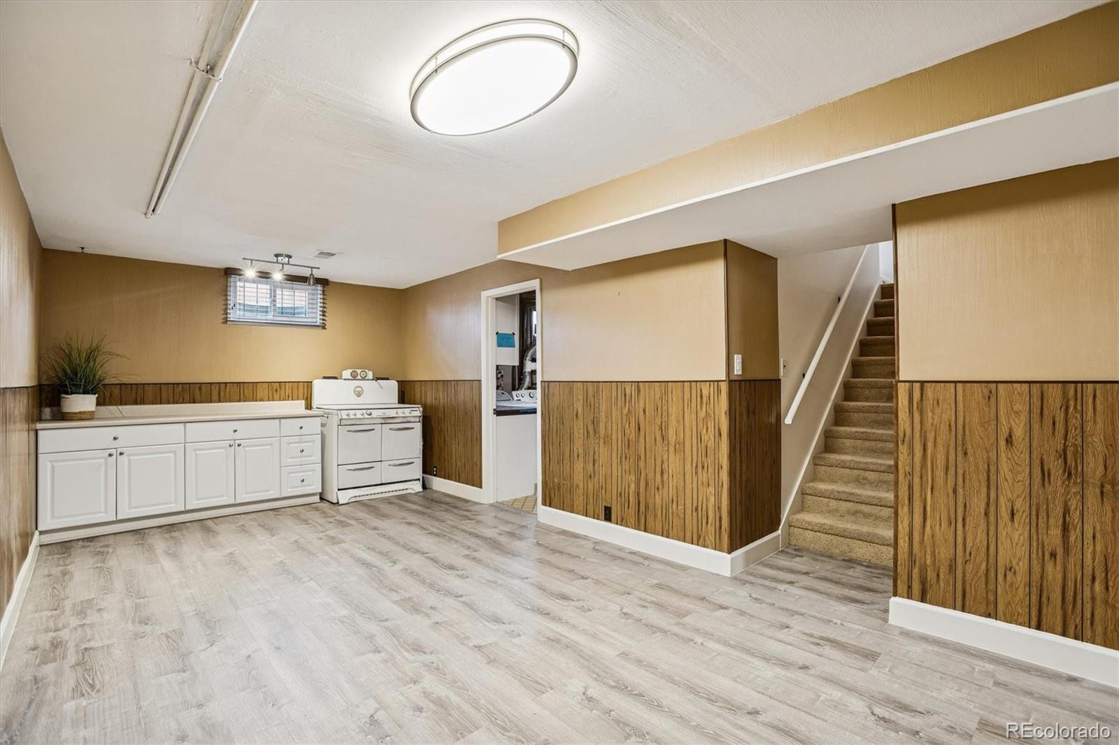 7798 Quivas Street Denver, CO 80221 - Photo 20 of 39 a kitchen with wooden floors and white appliances