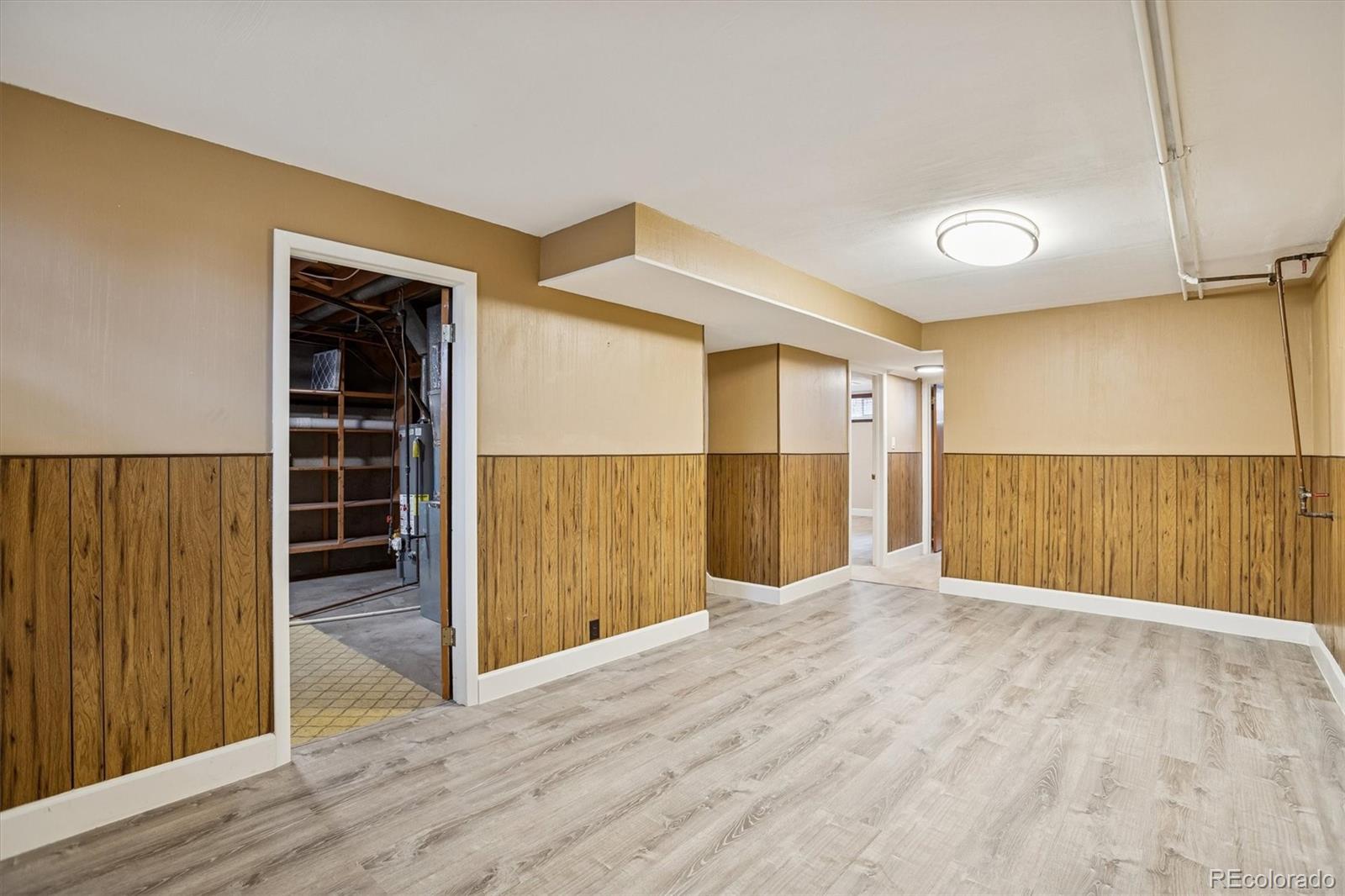 7798 Quivas Street Denver, CO 80221 - Photo 21 of 39 a view of a hallway with wooden floor and cabinet