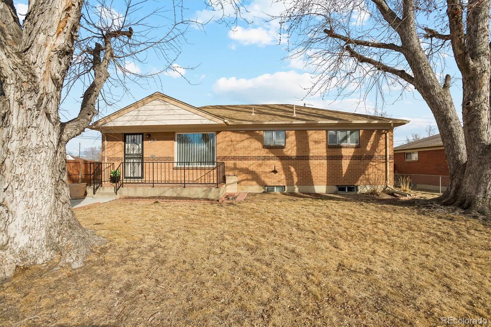 7798 Quivas Street Denver, CO 80221 - Photo 5 of 39 a front view of a house with a yard