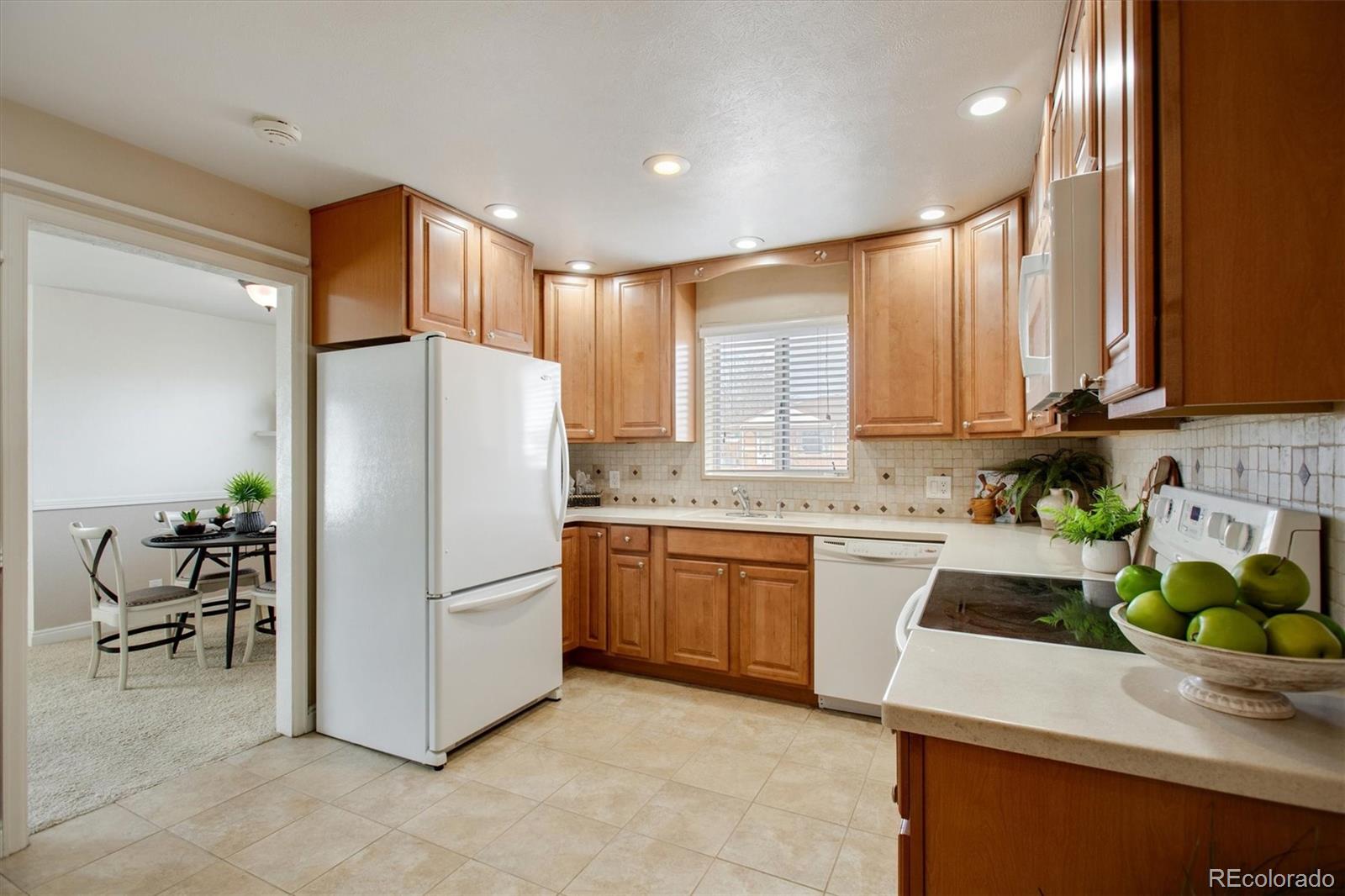 7798 Quivas Street Denver, CO 80221 - Photo 7 of 39 a kitchen with a refrigerator and a sink