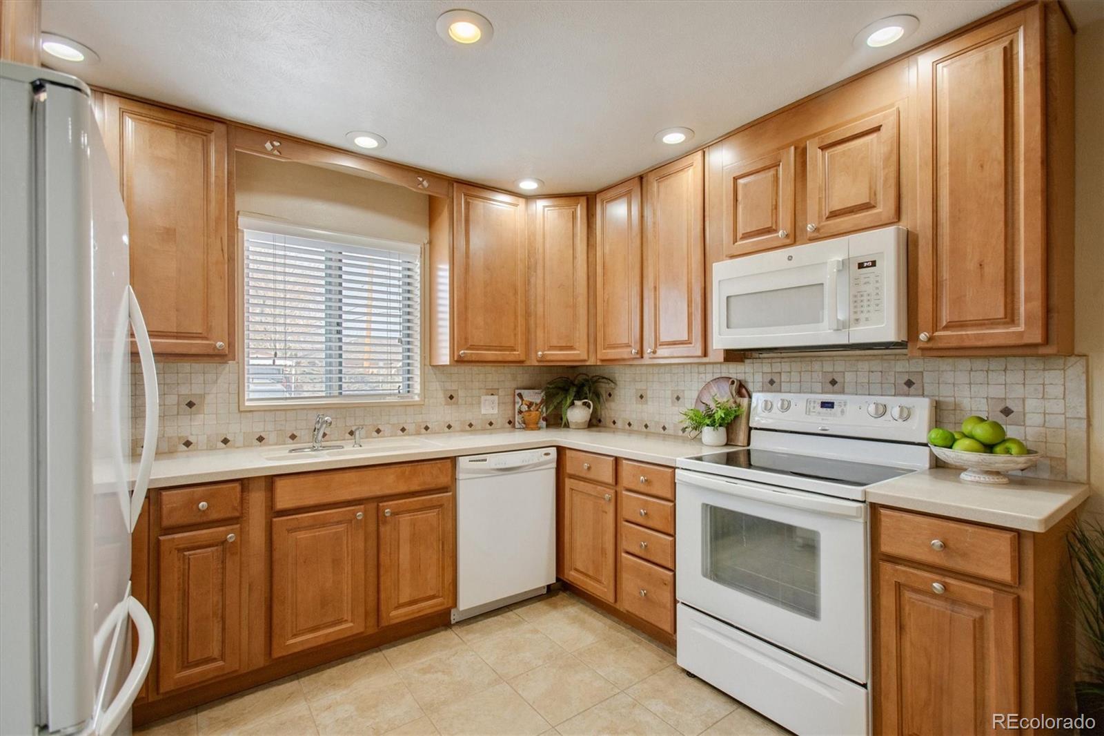 7798 Quivas Street Denver, CO 80221 - Photo 8 of 39 a kitchen with a sink stove top oven and cabinets