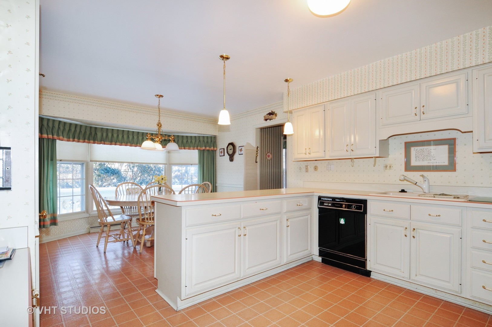 945 Anne Road Naperville, IL 60540 - Photo 3 of 10 a large white kitchen with lots of counter space and painting on the wall