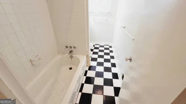 a bathroom with a black and white checkered floor