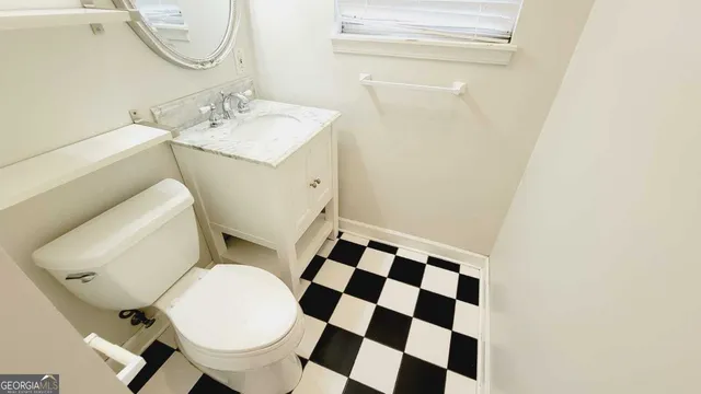 a bathroom with a sink mirror vanity and toilet