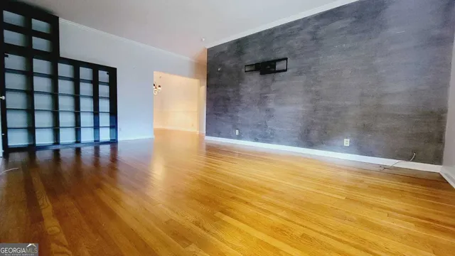 a view of a room with wooden floor and a window