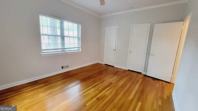 a view of empty room with wooden floor
