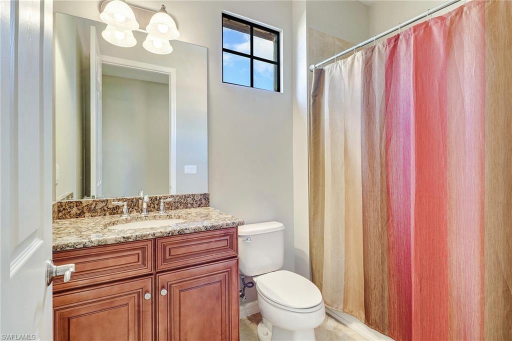8975 Malibu Street, Unit 1302 Naples, FL 34113 - Photo 19 of 34 a bathroom with a granite countertop sink toilet and mirror
