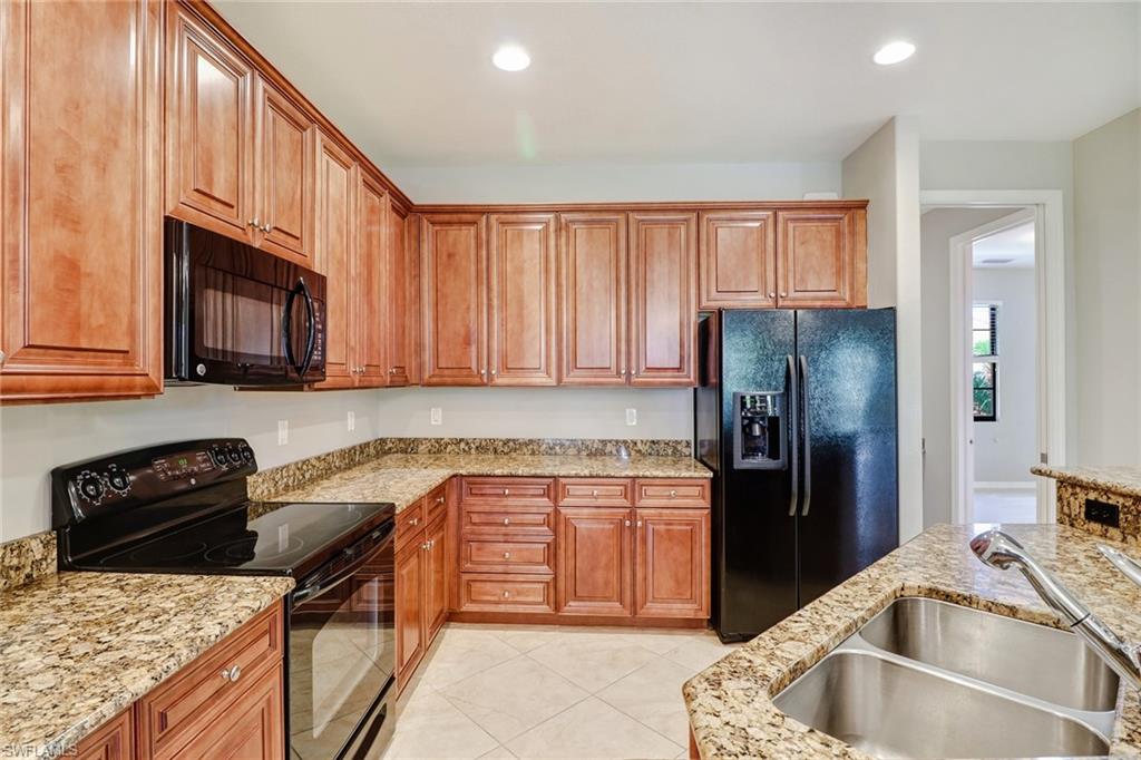 8975 Malibu Street, Unit 1302 Naples, FL 34113 - Photo 8 of 34 a kitchen with a sink stove and refrigerator