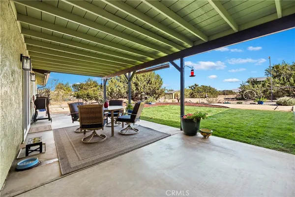 a view of a patio with table and chairs and potted plants