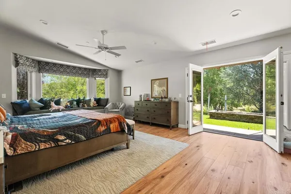 a spacious bedroom with a large bed and a chandelier
