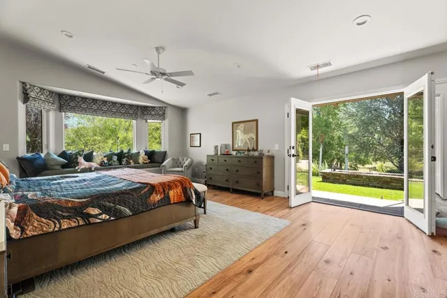a spacious bedroom with a large bed and a chandelier