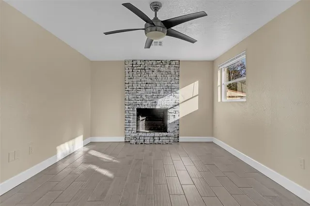 a view of an empty room with a fireplace and a window