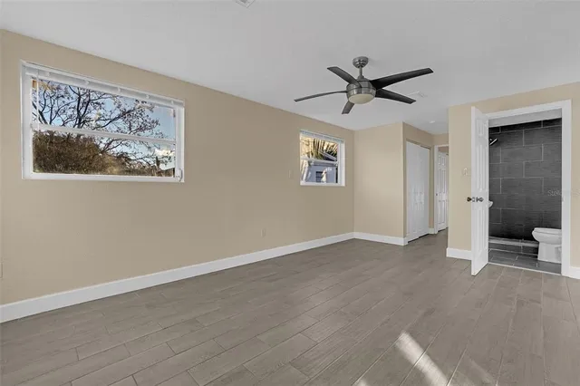 a view of a big room with wooden floor and windows