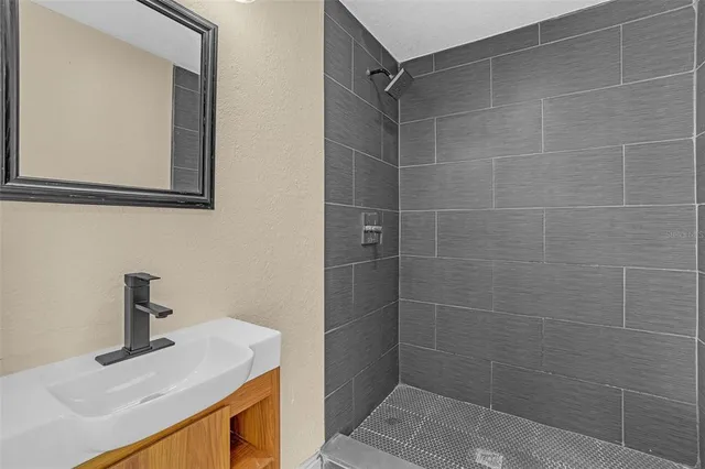 a bathroom with a sink a mirror and shower