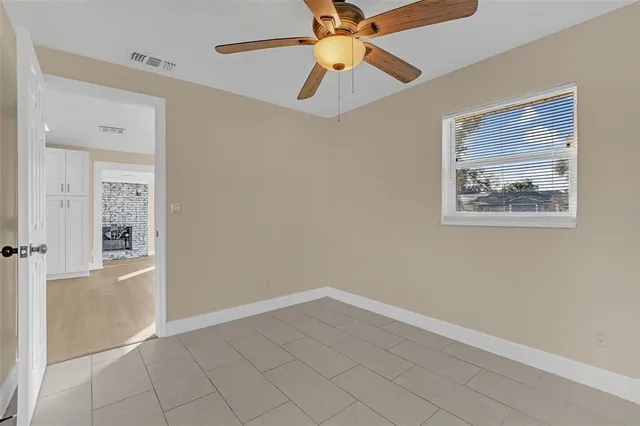 an empty room with windows and fan