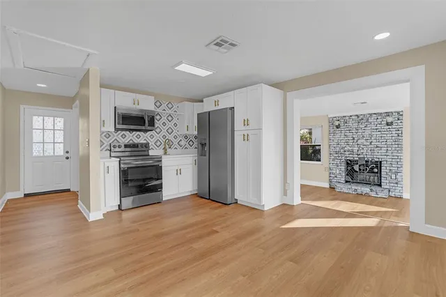 a view of a kitchen with a stove refrigerator and a fireplace