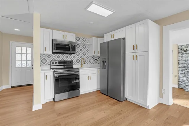 a kitchen with stainless steel appliances a stove microwave and refrigerator
