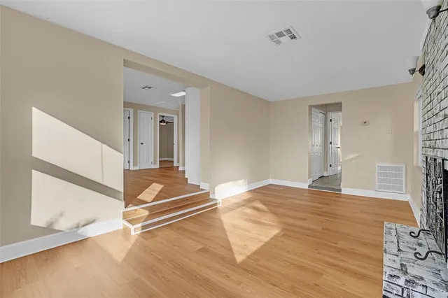 a view of a livingroom with wooden floor and a ceiling fan