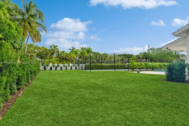 a view of a white house with a big yard