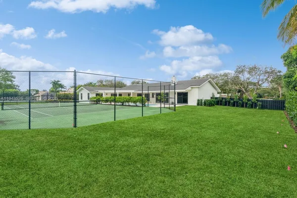 a view of a garden with a tree in front of the house