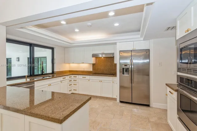 a large kitchen with a large window cabinets and stainless steel appliances