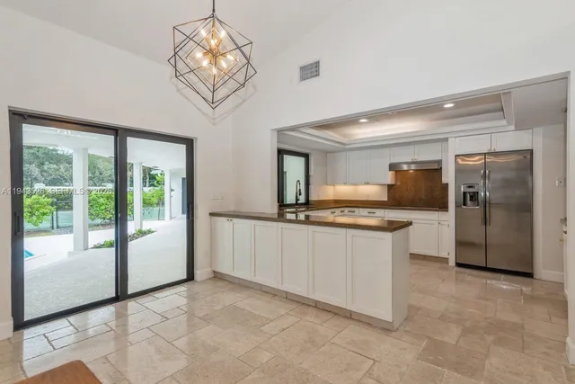 a view of a hallway with windows and chandelier