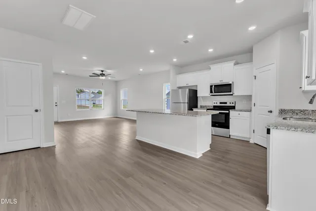 a kitchen with stainless steel appliances a refrigerator sink and microwave