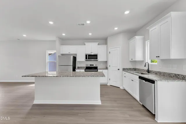 a large kitchen with stainless steel appliances lots of counter top space