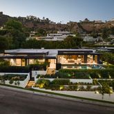 an outdoor view of a house with a garden and lake view