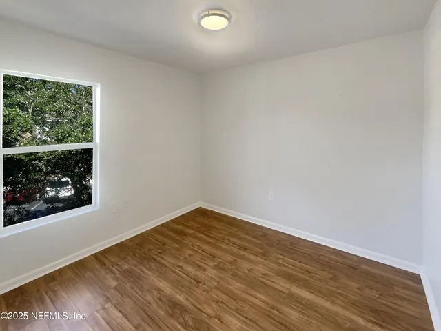 a view of a room with wooden floor and window