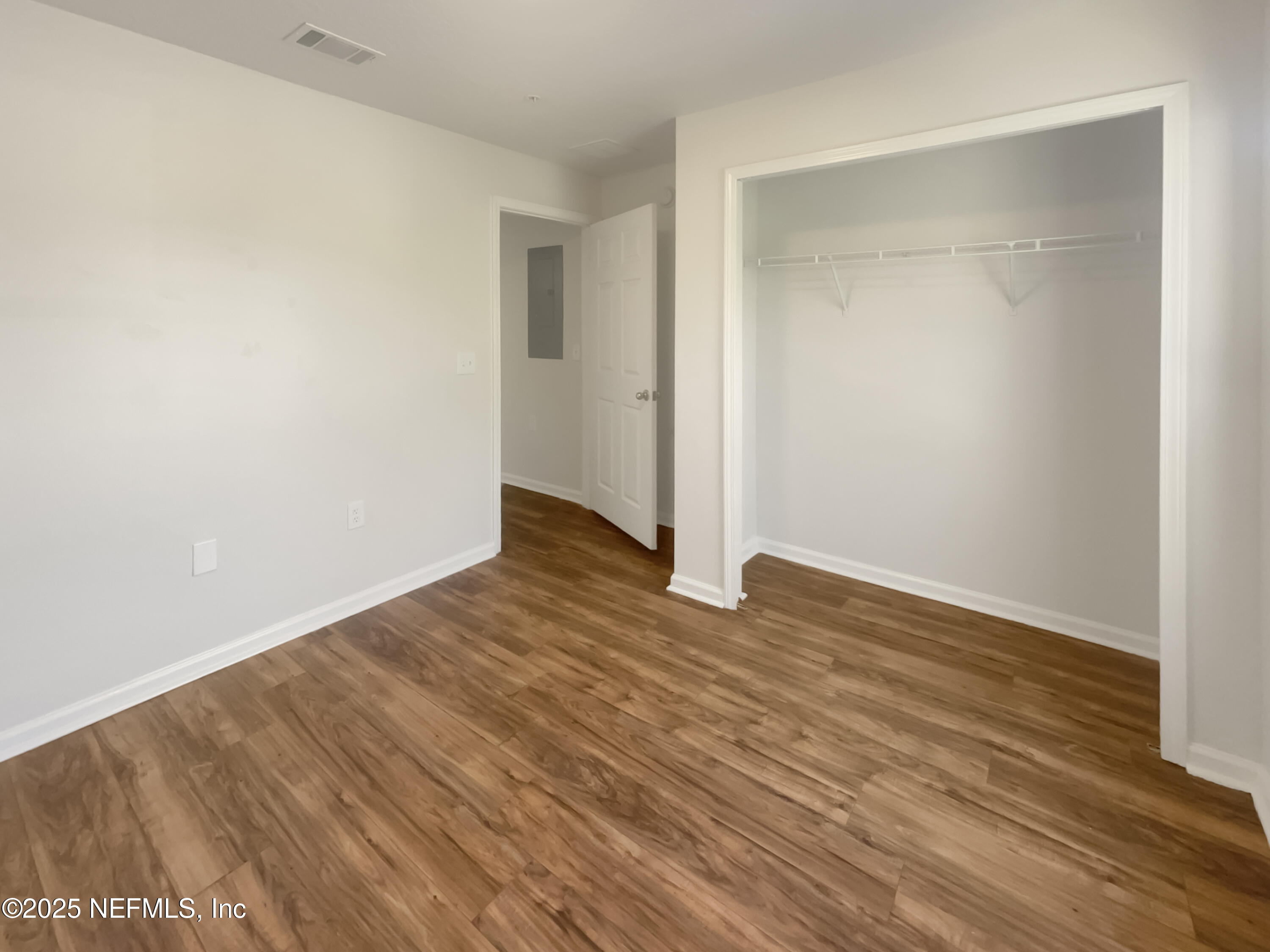 7920 Merrill Road, Unit 1115 Jacksonville, FL 32277 - Photo 16 of 19 a view of an empty room with wooden floor and a window