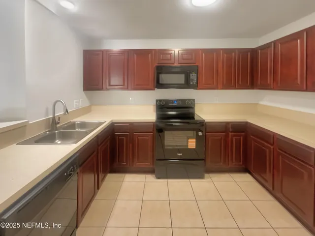 a kitchen with a sink a stove and cabinets