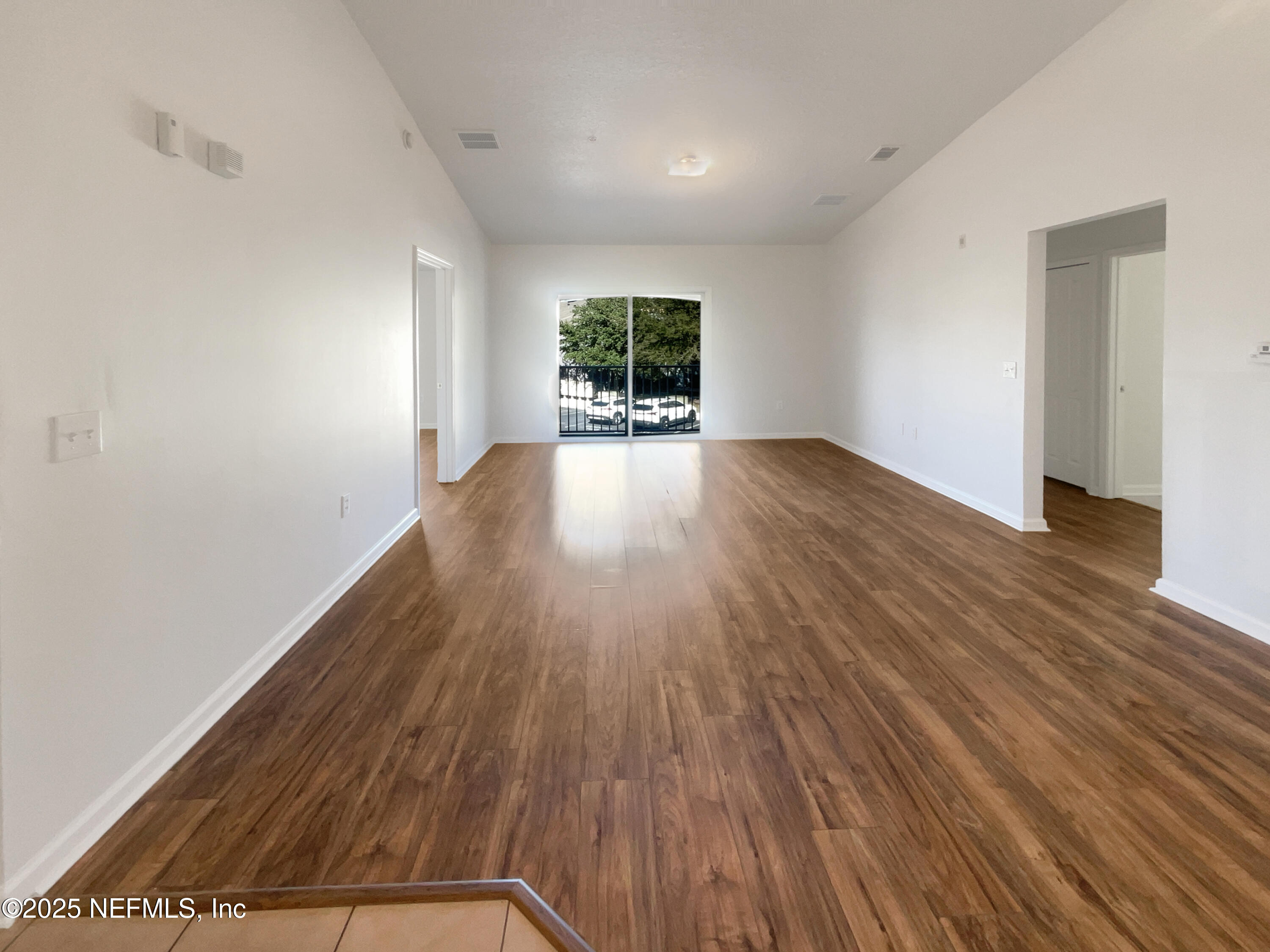 7920 Merrill Road, Unit 1115 Jacksonville, FL 32277 - Photo 3 of 19 wooden floor in an empty room with a window