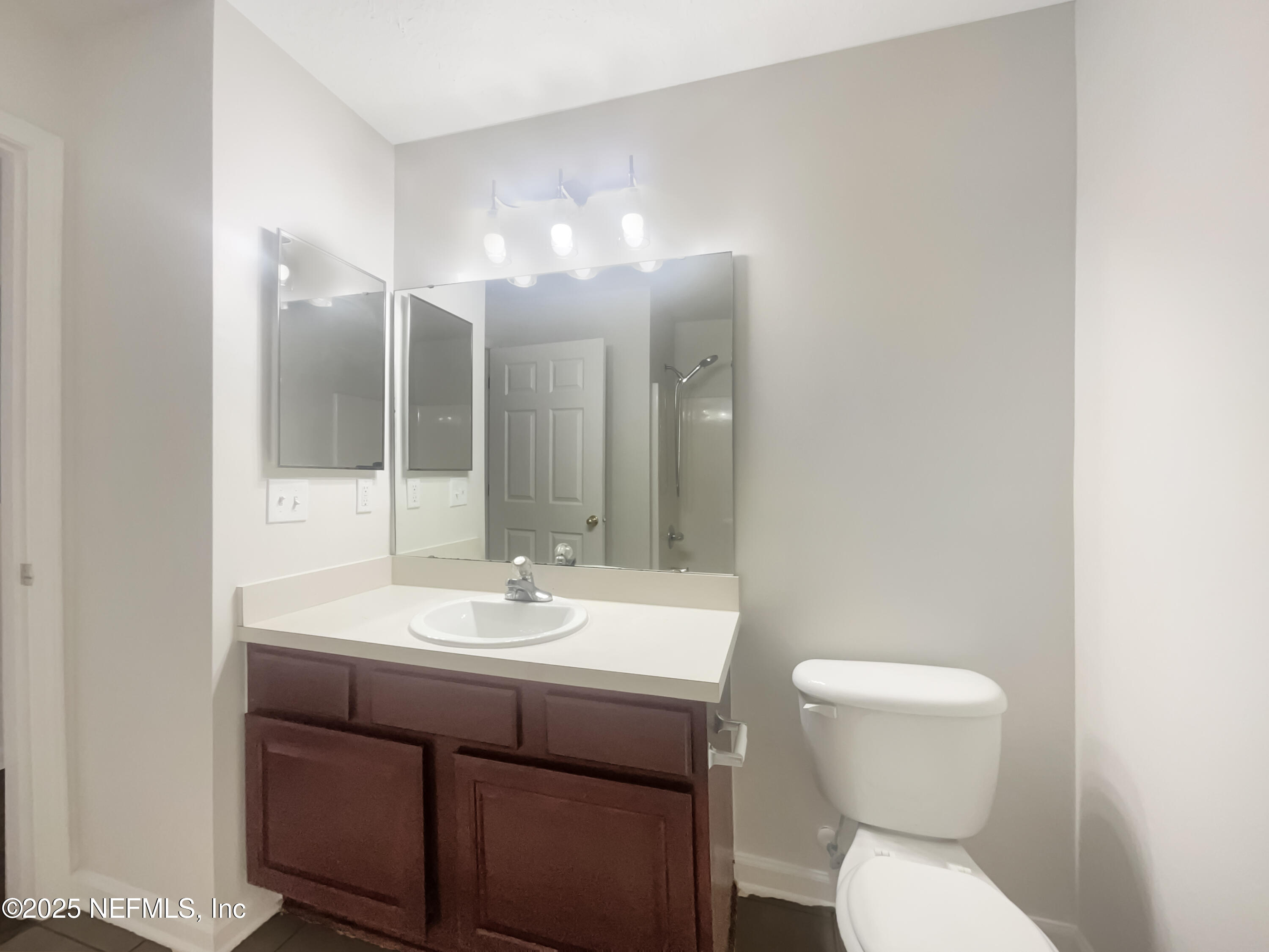 7920 Merrill Road, Unit 1115 Jacksonville, FL 32277 - Photo 8 of 19 a bathroom with a toilet sink and mirror
