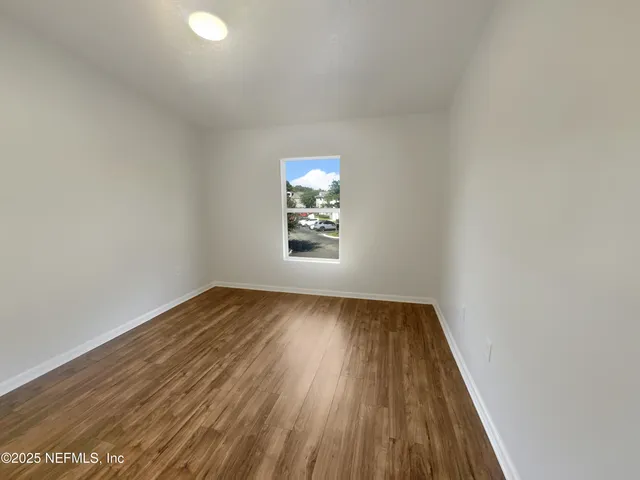 wooden floor in an empty room with a window