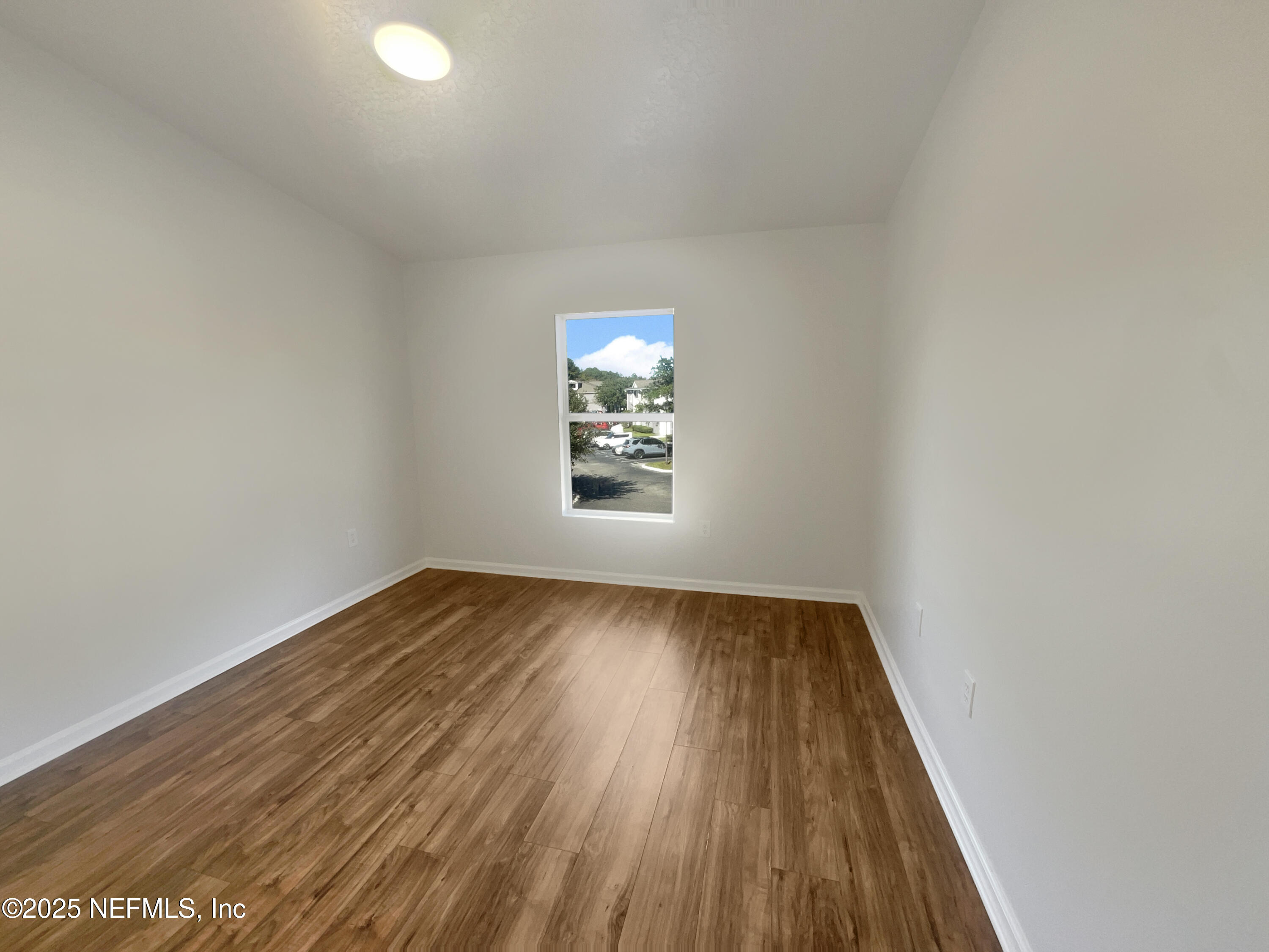 7920 Merrill Road, Unit 1115 Jacksonville, FL 32277 - Photo 9 of 19 wooden floor in an empty room with a window