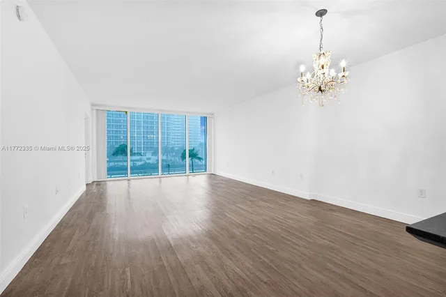 a view of a kitchen with wooden floor and a refrigerator