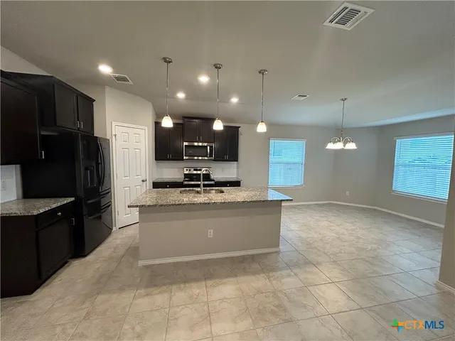 a view of kitchen with refrigerator sink and wooden floor