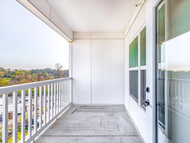 a view of a balcony with wooden floor and fence